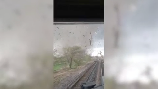 A screenshot from a video recorded in Waverly, Nebraska on April 26, 2024 of an EF-3 tornado moving toward a train on the tracks. 