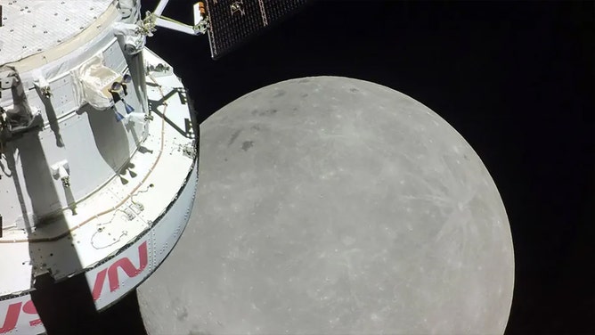 A portion of the far side of the Moon looms large just beyond the Orion spacecraft in this image taken on the sixth day of the Artemis I mission by a camera on the tip of one of Orion’s solar arrays. The darkest spot visible near the middle of the image is Mare Orientale.