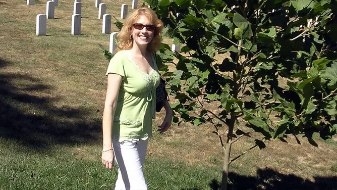 Rosemary Roosa, daughter of astronaut Stuart Roosa, stands next to the moon tree planted at Arlington National Cemetery in Virginia in honor of her father.