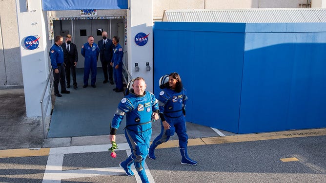 NASA astronauts Butch Wilmore, left, and Suni Williams, right, wearing Boeing spacesuits, are seen as they prepare to depart the Neil A. Armstrong Operations and Checkout Building for Launch Complex 41 on Cape Canaveral Space Force Station to board the Boeing CST-100 Starliner spacecraft for the Crew Flight Test launch, Monday, May 6, 2024, at NASA’s Kennedy Space Center in Florida