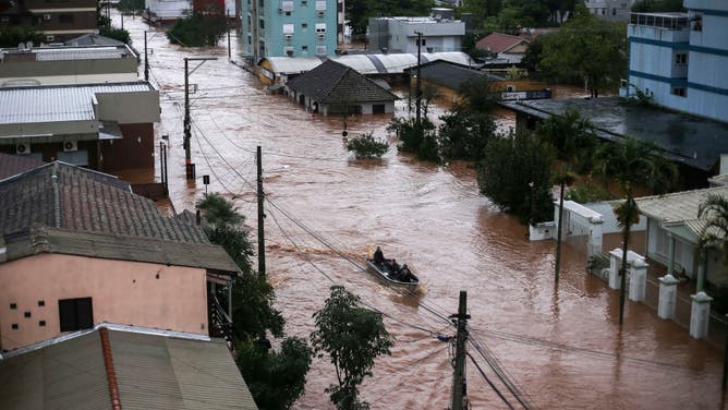 Volunteers use a fishing boat to rescue residents trapped inside their houses at the city center of Sao Sebastiao do Cai, Rio Grande do Sul state, Brazil on May 2, 2024.