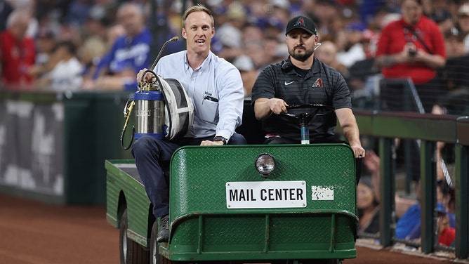 Beekeeper Matt Hilton (left) arrives to Chase Field to remove a colony of bees that formed on the net behind home plate during a delay to the MLB game between the Los Angeles Dodgers and the Arizona Diamondbacks on April 30, 2024 in Phoenix, Arizona.