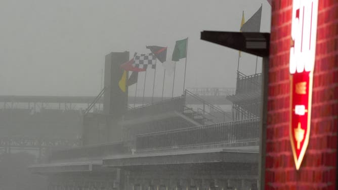 Racing flags wave in the rain during a rain delay before the start of the 108th running of the Indianapolis 500 on May 26, 2024, at the Indianapolis Motor Speedway in Indianapolis, Indiana.