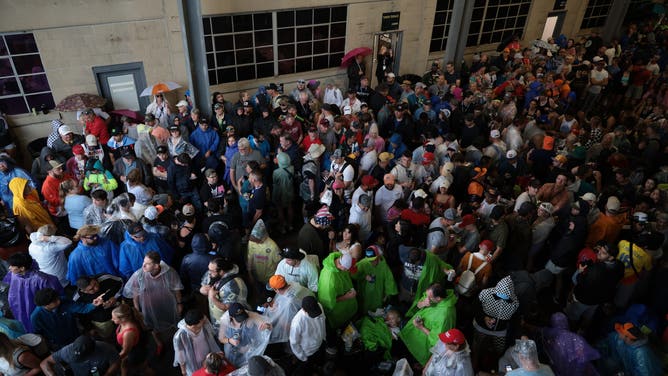 Fans wait for the rain to stop as the start is delayed for the 108th Running of the Indianapolis 500 at Indianapolis Motor Speedway on May 26, 2024 in Indianapolis, Indiana. (Photo by James Gilbert/Getty Images)