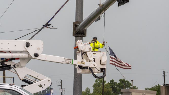 A Pearland city worker attempts to repair a broken power line following a severe thunderstorm that passed through the area Tuesday afternoon, May 28, 2024, in Pearland, Texas.