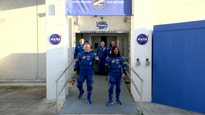 NASA astronauts Butch Wilmore and Suni Williams walk out of the Neil A. Armstrong Operations and Checkout Building on Monday, May 6, 2024, at Kennedy Space Center in Florida.