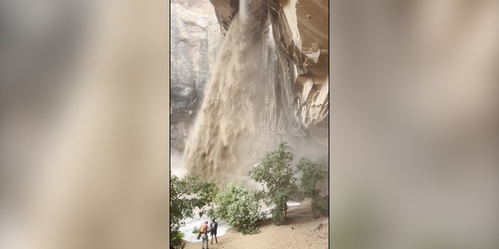 Climber rappels next to raging muddy waterfall sparked by flash floods in Utah