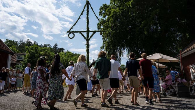 People dance around the Midsommar maypole in Wira, north of Stockholm, Sweden, on June 23, 2023. Midsommar, also known as Midsummer, is a popular traditional festival celebrated in Sweden. It takes place on the weekend closest to the summer solstice.