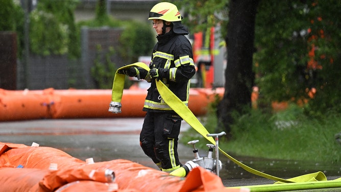 A firefighter works on a flood protection at a flooded street in the small Bavarian village of Eichenau, southern Germany, on June 1, 2024. After heavy rainfall in the last days floods are expected in southern Germany.