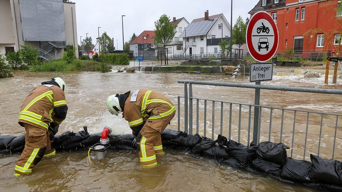 Firefighters pile up sandbags as a protective wall in Ochsenhausen. The River Rottum has burst its banks and parts of the town center are under water.