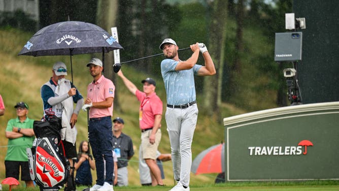 Sam Burns plays a shot from the 18th hole tee as rain falls during the third round of the Travelers Championship at TPC River Highlands on June 22, 2024, in Cromwell, Connecticut.
