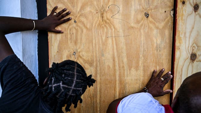 People board up the windows of a shop in preparation for the arrival of Hurricane Beryl in Bridgetown, Barbados on June 30, 2024.