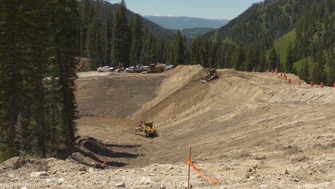 The photo shows Evans Construction working on temporary detour at mile marker 12.8 on Teton Pass in Wyoming.
