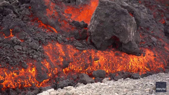 This image captured from a video recorded by Marco Di Marco shows red-hot lava flowing over a main road to and from the evacuated town of Grindavik in Iceland after a volcanic eruption that began at the end of May 2024.