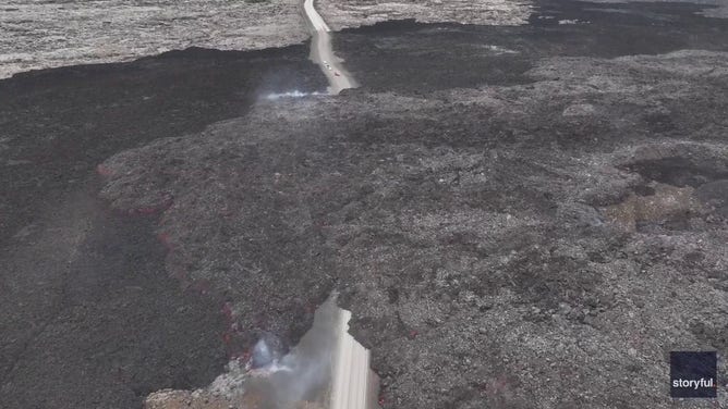This image captured from a video recorded by Marco Di Marco shows red-hot lava flowing over a main road to and from the evacuated town of Grindavik in Iceland after a volcanic eruption that began at the end of May 2024.