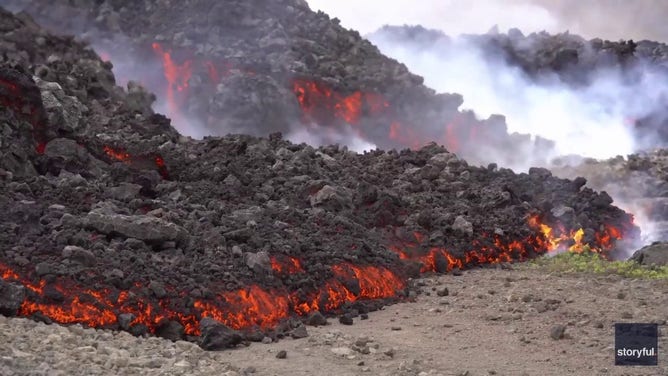 This image captured from a video recorded by Marco Di Marco shows red-hot lava flowing over a main road to and from the evacuated town of Grindavik in Iceland after a volcanic eruption that began at the end of May 2024.