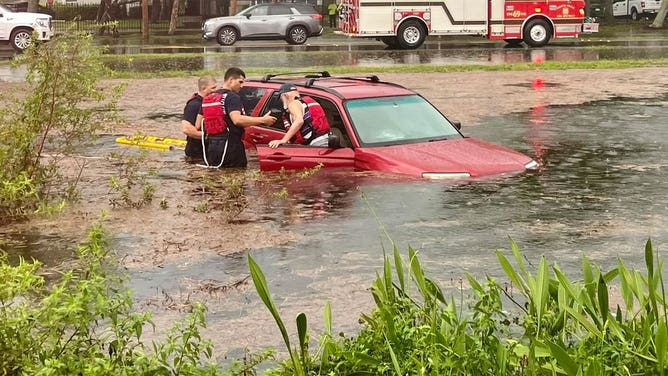 First responders rescue a person from a vehicle surrounded by floodwater in Fort Myers, Florida, on June 12, 2024.