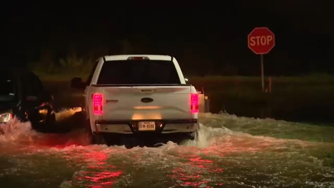 A vehicle navigates a flooded roadway in Baytown, Texas, on July 26, 2024.