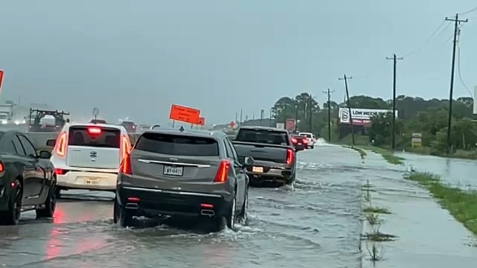 Vehicles navigate a flooded road near Interstate 45 in Houston on July 26, 2024.