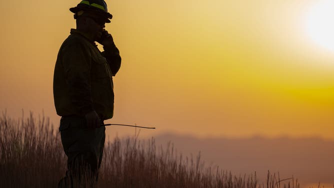 A firefighter stands near the Sandhurst Fire outside Salt Lake City on Saturday, July 20, 2024.