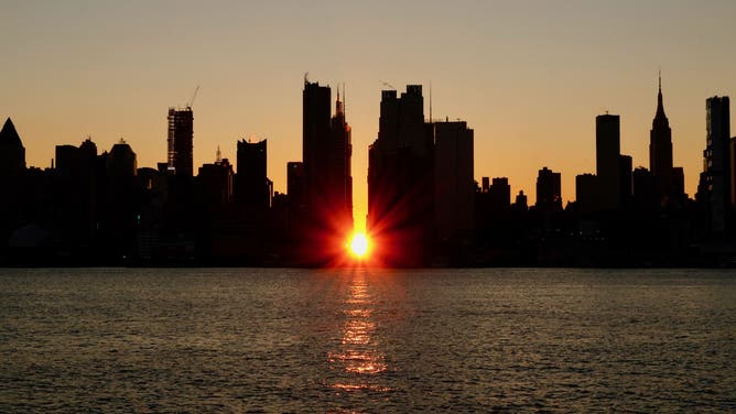 The sun rises over 42nd street during a sunrise Manhattanhenge in New York City on November 29, 2023, as seen from Weehawken, New Jersey.