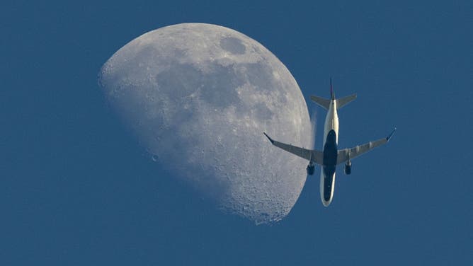 A waxing gibbous moon rises as a Delta Connection Embraer E175LR aircraft approaches Los Angeles International Airport from Sacramento on June 15, 2024