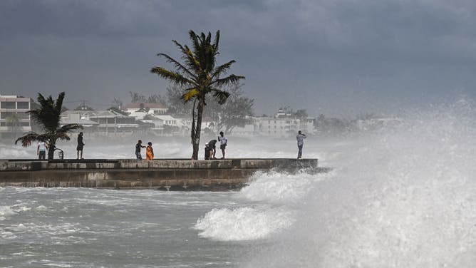 People visit a pier during a high tide after the passage of Hurricane Beryl in Oistins near Bridgetown, Barbados on July 1, 2024.