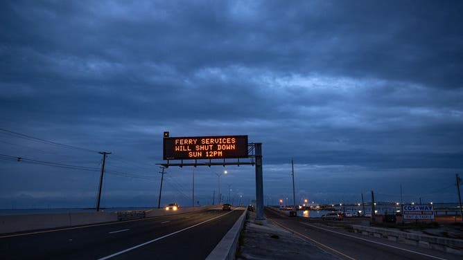 A warning sign on South Padre Island Drive and JFK Causeway ahead of Hurricane Beryl's landfall in Corpus Christi, Texas, US, on Sunday, July 7, 2024. Tropical Storm Beryl, currently in the Gulf of Mexico, is projected to create storm surge late Sunday and Monday from Corpus Christi to just south of Houston, according to the National Hurricane Center.