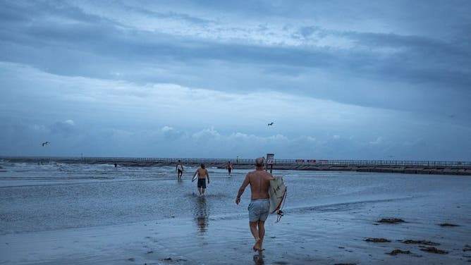 Surfers on North Padre Island ahead of Hurricane Beryl's landfall in Corpus Christi, Texas, US, on Sunday, July 7, 2024. Tropical Storm Beryl, currently in the Gulf of Mexico, is projected to create storm surge late Sunday and Monday from Corpus Christi to just south of Houston, according to the National Hurricane Center.