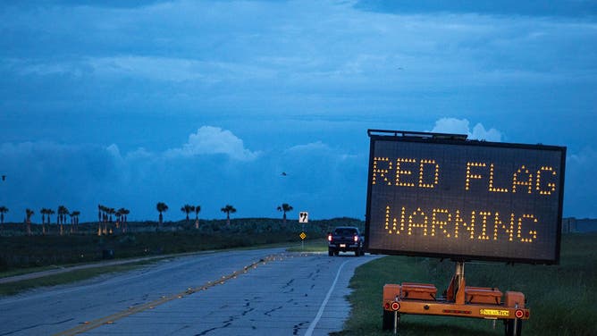 A red flag warning sign on a North Padre Island beach access road ahead of Hurricane Beryl's landfall in Corpus Christi, Texas, US, on Sunday, July 7, 2024.