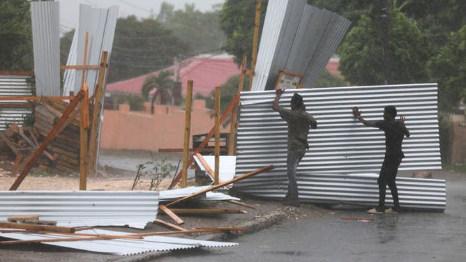 Workers save pieces of a tin fence that was blown apart as winds from Hurricane Beryl pass through the area on July 03, 2024, in Kingston, Jamaica. Category 4 storm Beryl has caused widespread damage in several island nations as it continues to cross the Caribbean.