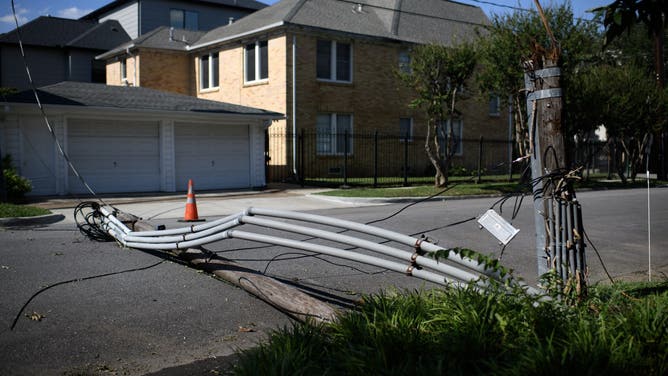 A snapped utility pole in the middle of a street in Houston, Texas, US, on Tuesday, July 9, 2024. Houston is baking under dangerous heat as more than 2 million homes and businesses in the area remain without power after Hurricane Beryl and signs of fuel shortages begin to emerge. Photographer: Mark Felix/Bloomberg via Getty Images