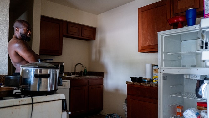 Gary Rawls looks at his near-empty refrigerator while speaking about his situation from his apartment in the Kashmere Gardens neighborhood on July 11, 2024 in Houston, Texas.