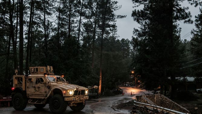 A National Guard truck parked at the entrance to the Upper Canyon neighborhood alerts residents that the area is closed on July 17, 2024 in Ruidoso, NM.