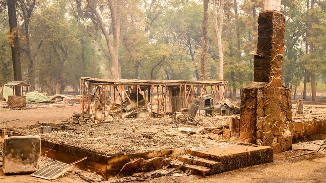 A burned home smolders during the Park fire near the Paynes Creek area of unincorporated Tehama County, California, on July 27, 2024. (Photo by JOSH EDELSON / AFP) (Photo by JOSH EDELSON/AFP via Getty Images)