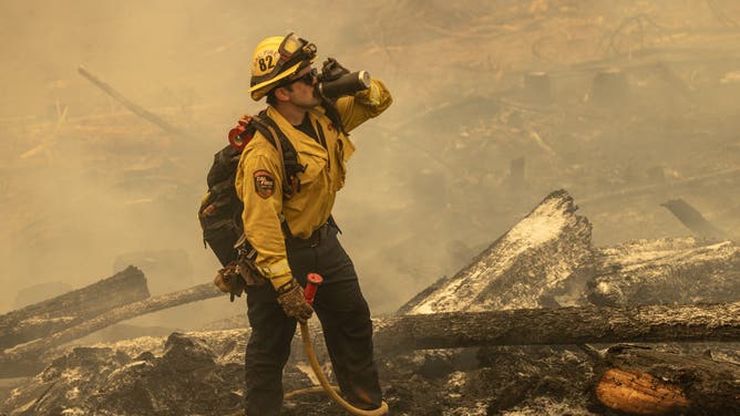 CHICO, CALIFORNIA - JULY 28: A firefighter pauses to hydrate on the eastern front of the Park Fire. (Photo by David McNew/Getty Images)