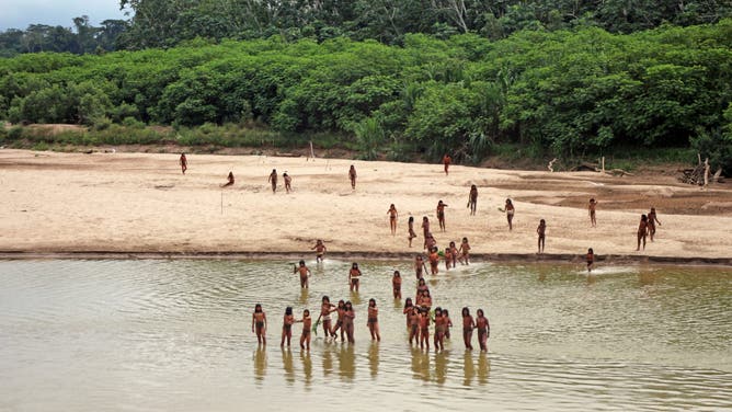 A photo shared by the indigenous rights group Survival International shows dozens of people from the Mashco Piro tribe recently seen on a riverbank near Monte Salvado — a village of the Yine people – in southeast Peru.