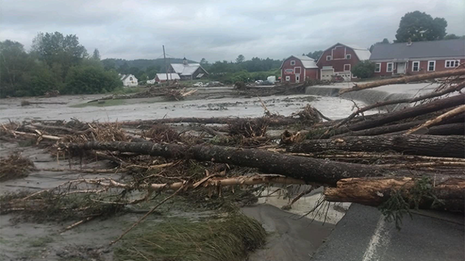 Trees are seen laying across a flooded road in Lyndon, Vermont, on Tuesday, July 30, 2024.