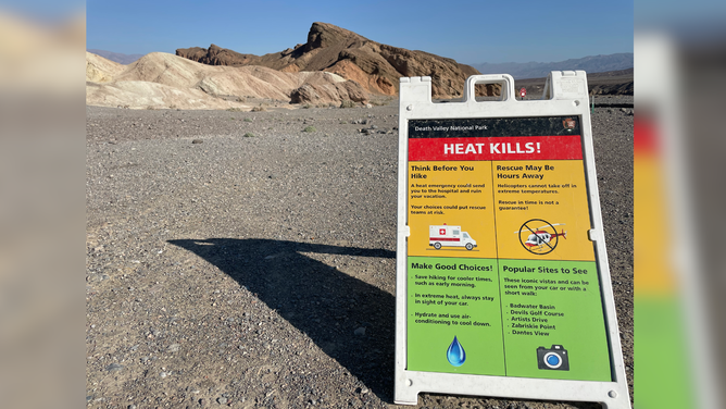 A sign at the Badlands Loop Trailhead at Zabriskie Point provides heat safety information.