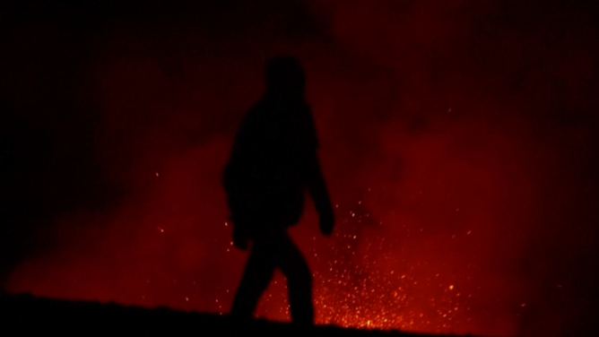 Person walking by crater.