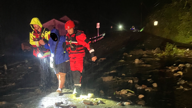 Rescuers are seen helping a resident get to safety after catastrophic flooding was reported in the St. Johnsbury, Vermont, area, on Tuesday, July 30, 2024.