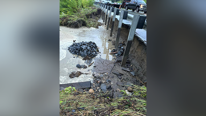 Rocks and debris are seen in the water below a road near Saint Johnsbury, Vermont.