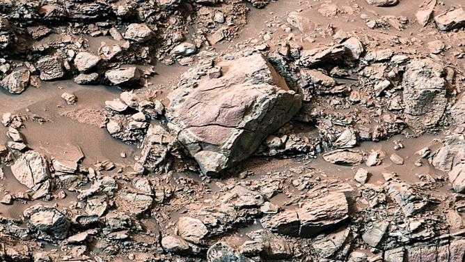 While exploring Gediz Vallis channel in May, NASA’s Curiosity captured this image of rocks that show a pale color near their edges. These rings, also called halos, resemble markings seen on Earth when groundwater leaks into rocks along fractures, causing chemical reactions that change the color.