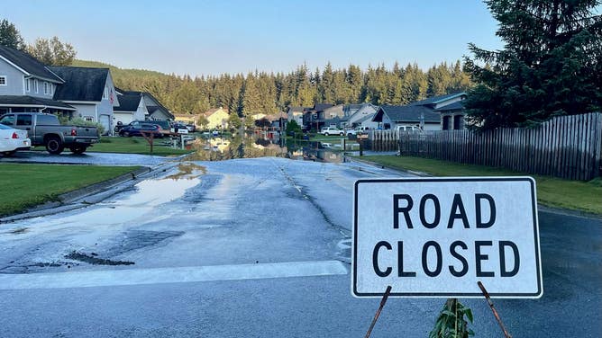 Road in a neighborhood is closed due to flooding.