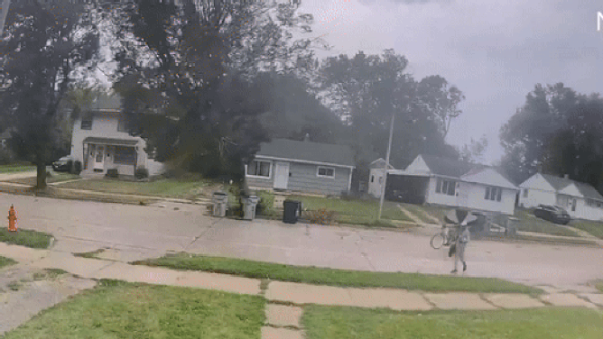 This image shows a falling tree narrowly missing a bicyclist in Milwaukee as severe weather ripped across Wisconsin on Tuesday, Aug. 28, 2024.