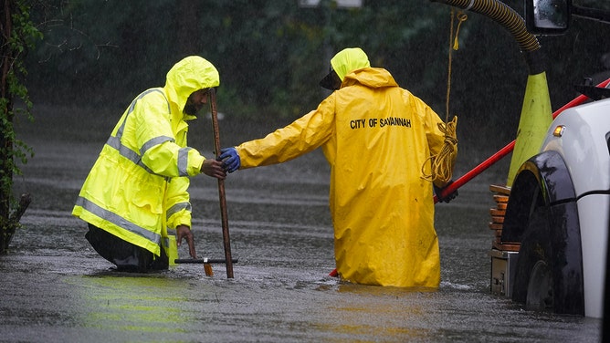 Crews work to help water drain as homes are flooded in the Tremont Park neighborhood August 6, 2024 in Savannah, Georgia.