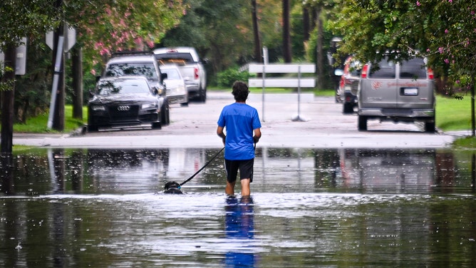 A man walks on a flooded street due to Tropical Storm Debby on August 06, 2024 in Charleston, South Carolina.