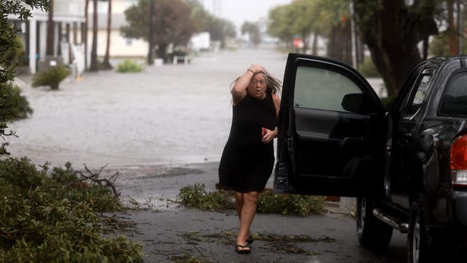 CEDAR KEY, FLORIDA - AUGUST 05: Christy Hatcher checks on her neighborhood as high winds, rain and storm surge from Hurricane Debby inundate the area on August 05, 2024, in Cedar Key, Florida. Hurricane Debby brings rain storms and high winds along Florida’s Big Bend area. (Photo by Joe Raedle/Getty Images)