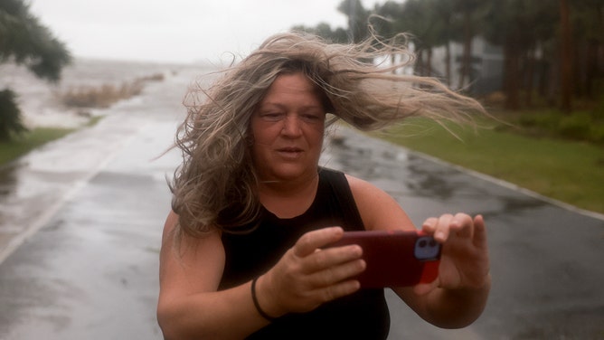 Christy Hatcher checks on her neighborhood as high winds, rain and storm surge from Hurricane Debby inundate the area on August 05, 2024, in Cedar Key, Florida.