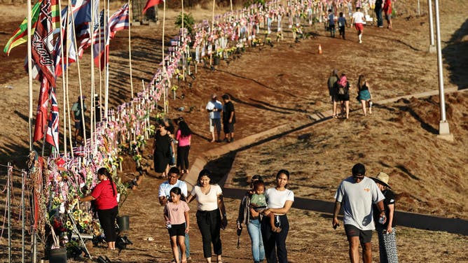 People gather at a public hillside memorial to Lahaina wildfire victims on August 7, 2024 in Lahaina, Hawaii.